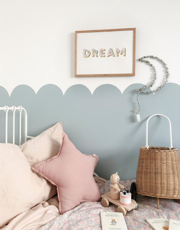 Dream nursery print on nursery wall with blue scallop detail.