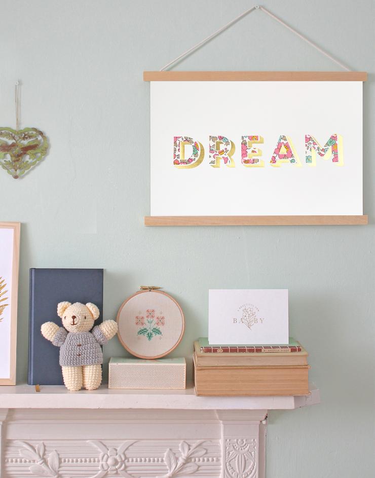 Dream Liberty print nursery art by The Charming Press with wooden frame hanging in child's bedroom. 