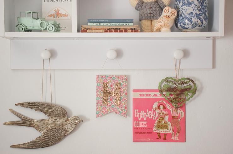 Betsy ann Liberty print glitter monogram flag hanging on a shelf in a nursery.