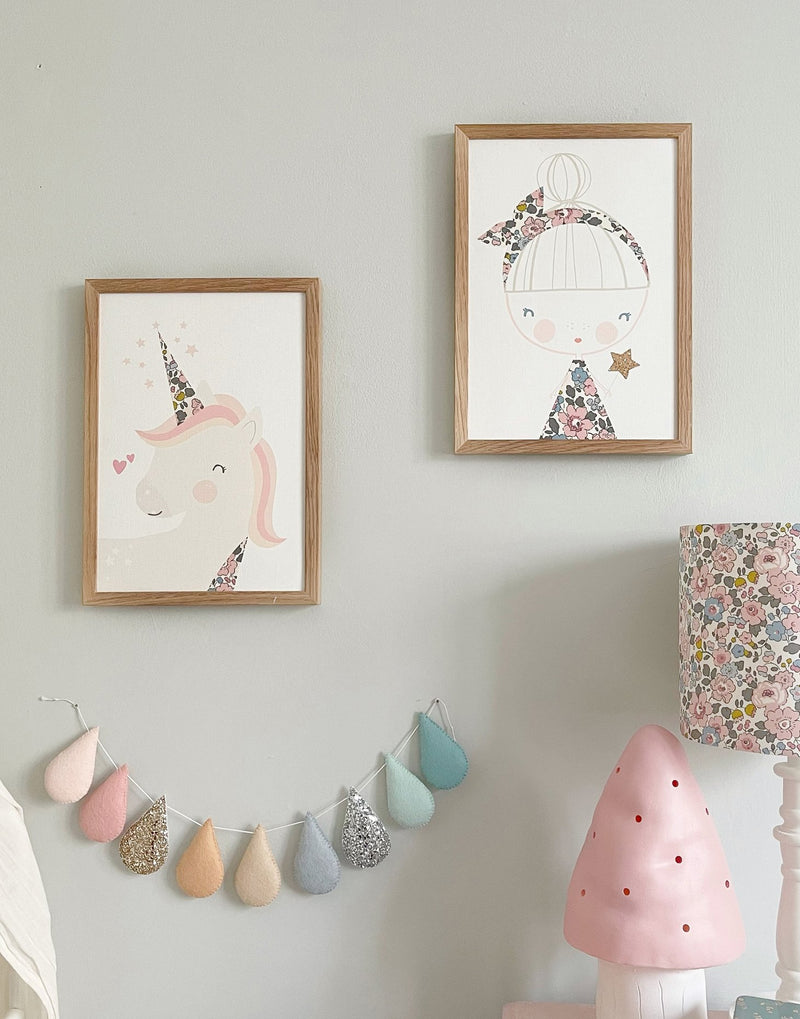 Children's bedroom gallery wall with prints from The Charming Press featuring magical unicorn and glitter fairy.