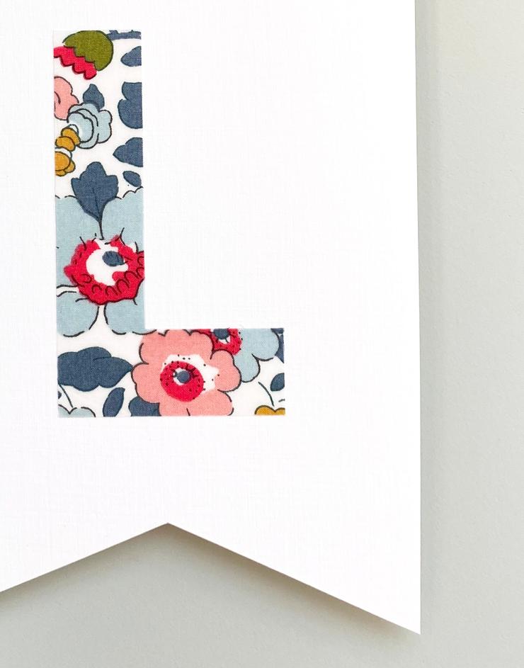 Close up of Liberty mini monogram nursery flag by The Charming Press.