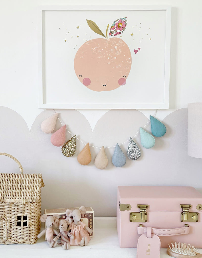 Nursery decor shown with Liberty print peach wall art and other accessories.