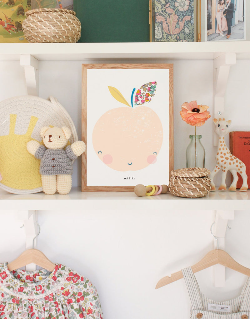 Baby's nursery showing Liberty print Peach print by The Charming Press and other child's accessories.