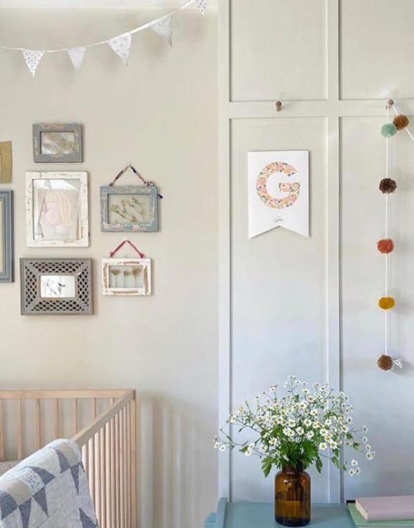 Nursery with wall art and prints including monogram nursery flag, personalised with Liberty fabric and child's initial.
