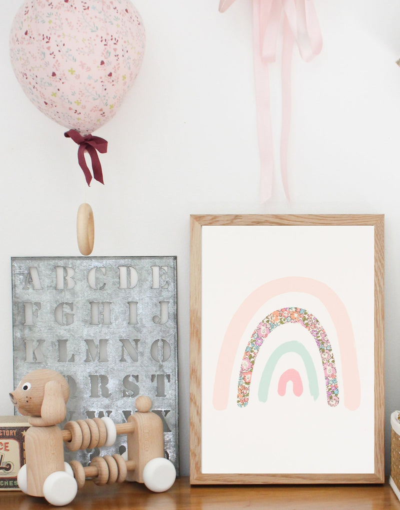 Pastel rainbow print featuring Liberty print fabrics by The Charming Press shown on a children's bedroom shelf.